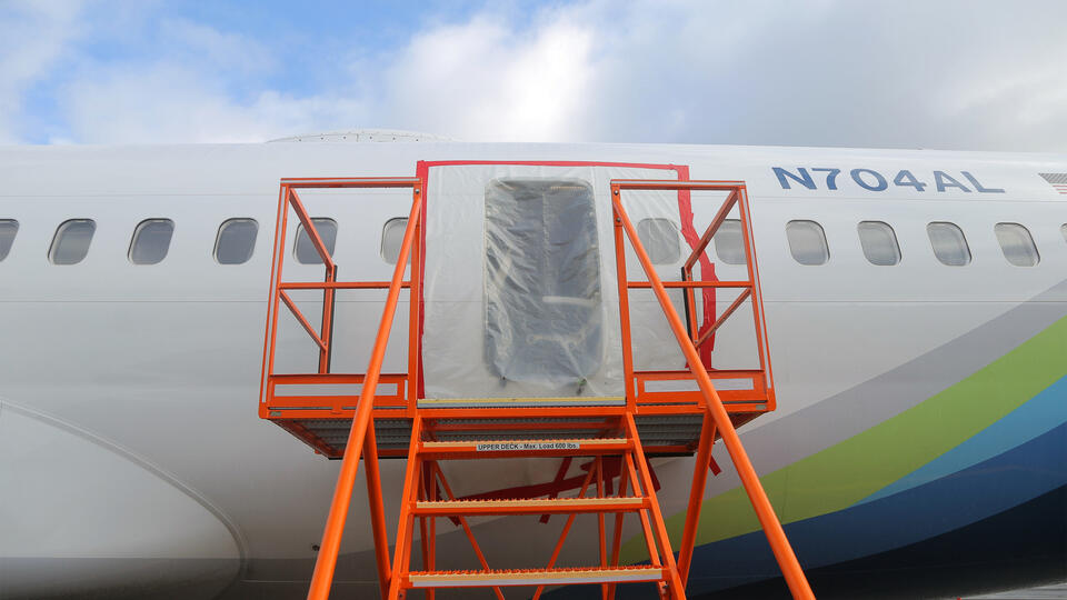 An airplane fuselage with plastic sheeting over an opening
